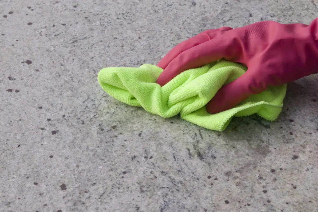 Cleaning a granite kitchen worktop with a rag