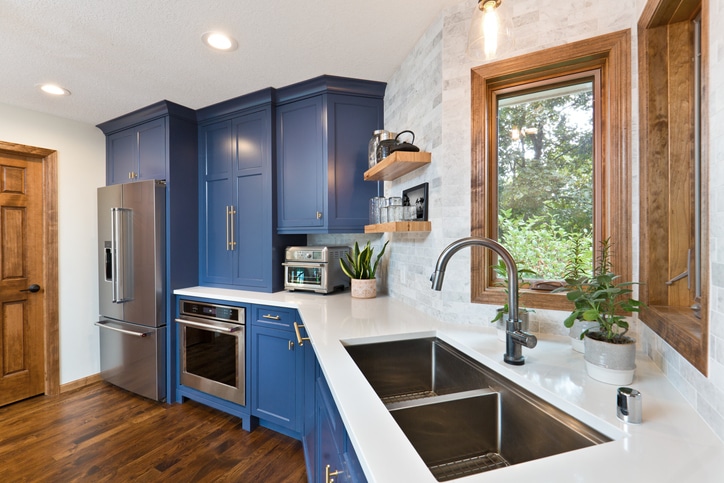 A contemporary kitchen renovation remodeling featuring a hardwood floor  kitchen sink, appliances and quartz counter top.