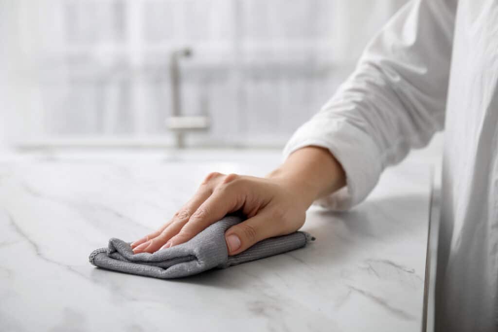 Woman safely cleaning marble countertops