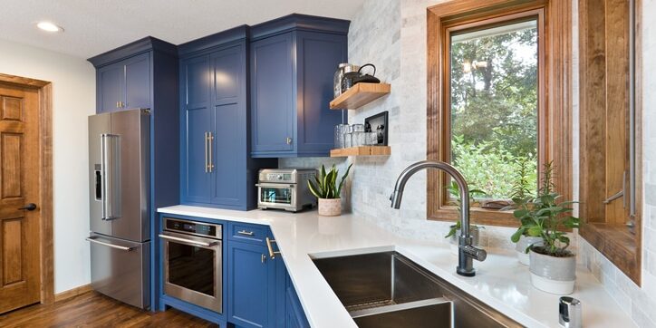 A contemporary kitchen renovation remodeling featuring a hardwood floor  kitchen sink, appliances and quartz counter top.